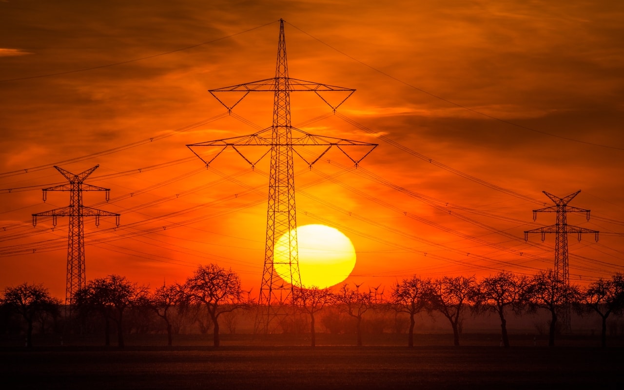 sunset behind transmission towers